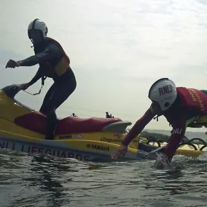 Lifeguard jumping from a rescue watercraft