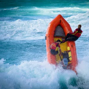 Lifeguards on an arancia inshore rescue boat in the surf at Perranporth beach, Cornwall