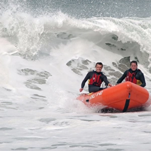 Two lifeguards on an arancia IRB in surf at St Agnes