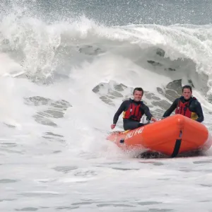 Two lifeguards on an arancia IRB in surf at St Agnes