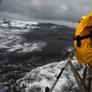 Lizard Tyne class lifeboat David Robinson 47-030 in rough weather. Crew members can be seen holding onto the side of the lifeboat as she lists over to the port side