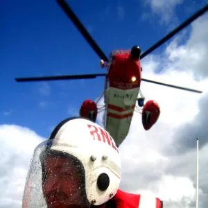 Portrait shot of a coastguard helicopter above an RNLI ILB crew