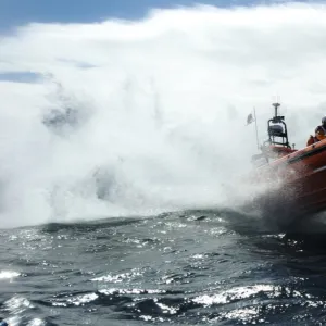 Red Bay Altantic 85 inshore lifeboat Geoffrey Charles B-843. Lifeboat moving from left to right at speed, four crew on board, lots of white spray, bow high out of the water