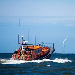 Rhyl Mersey class lifeboat Lil Cunningham 12-24 heading out to sea, windfarms in the distance