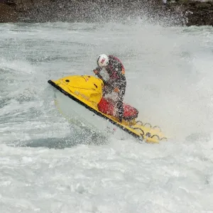 RNLI lifeguard heading out through surf on a rescue watercraft