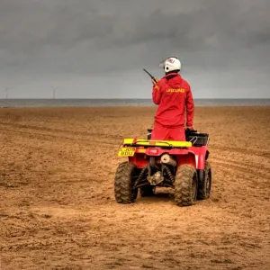 RNLI lifeguard on a quad bike patrol vehicle at Skegness beach