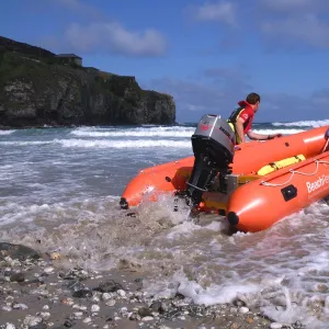 Two RNLI lifeguards launching an Arancia inshore rescue boat