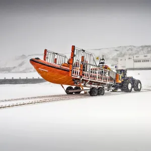 Sheringham Atlantic 85 inshore lifeboat The Oddfellows B-818 on a launching trailer on the beach, snow covering everything and station in the background