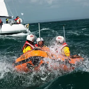 Solent lifeboats provide safety cover during the annual Round the Island Race. Yachts sailing past the Needles. D-class inshore lifeboat pictured