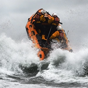 St Agnes D-class inshore lifeboat Blue Peter IV D-641 heading through a breaing wave. Crew members Gavin Purcell, Gavin forehead and Richard Llewellyn on board