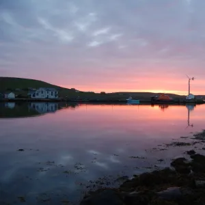 Sunset over Aith lifeboat station and harbour. Severn class lifeboar charles Lidbury 17-14 moored up, wind turbine visible