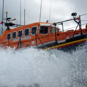 Swanage mersey class lifeboat Robert Charles Brown 12-23. Lots of white spray, crew member stood at the stern