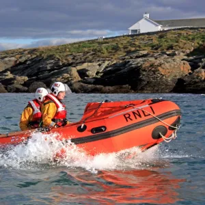 Trearddur Bay D-class inshore lifeboat Flo and Dick Smith D-614 during a training exercise. Lifeboat moving from left to right, three crew on board