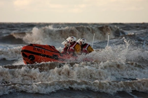 Blackpool D-class inshore lifeboat D-729 in surf, three crew on board Blackpool D-class inshore lifeboat D-729 in surf, three crew on board