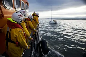 Bronze medal for gallantry reconstruction on board the Dunbar Trent class lifeboat John Neville Taylor 14-35. Crew members lined up on deck, yacht in the distance