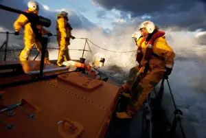 Crew members stood at the bow of the Berwick-upon-Tweed Mersey class lifeboat Joy and Charles Beeby 12-32, lots of spray