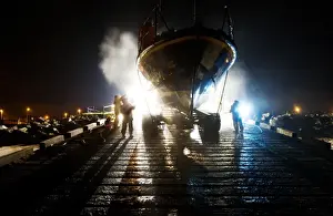 Hoylake mersey class lifeboat Lady of Hilbre 12-005 being washed down by shore crew on the slipway at night. Taken from The Lifeboat: Courage on our Coasts. Page 37