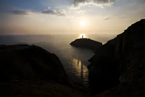 Landscape shot of sun setting behind lighthouse near Beaumaris