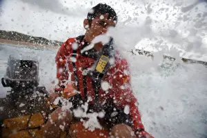 Lifeguard at the helm of an arancia inshore rescue boat at Constantine Bay, Cornwall