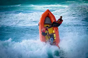 Lifeguards on an arancia inshore rescue boat in the surf at Perranporth beach, Cornwall