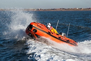 Lytham St Annes D-class inshore lifeboat Sally D-657. Lifeboat moving from right to left, two crew on board Lytham St Annes D-class inshore lifeboat Sally D-657. Lifeboat moving from right to left, two crew on board