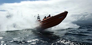 Red Bay Altantic 85 inshore lifeboat Geoffrey Charles B-843. Lifeboat moving from left to right at speed, four crew on board, lots of white spray, bow high out of