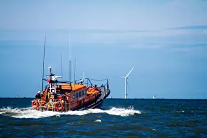 Rhyl Mersey class lifeboat Lil Cunningham 12-24 heading out to sea, windfarms in the distance