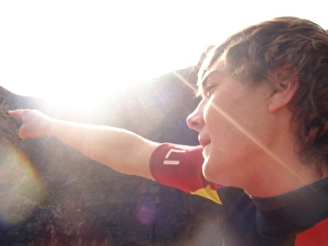 <b class=qtipBold><figcaption>RNLI lifeguard</figcaption></b><br>Picture shows young RNLI lifeguard pointing to the left of the picture, with sun shinning brightly towards the camera.<br><em>© RNLI 2008 - All Rights Reserved</em> RNLI lifeguard