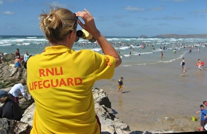 An RNLI lifeguard monitoring the busy Perranporth beach An RNLI lifeguard monitoring the busy Perranporth beach