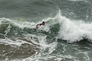 An RNLI lifeguard swimming through heavy surf at Perranporth An RNLI lifeguard swimming through heavy surf at Perranporth