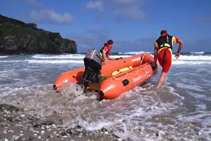 Two RNLI lifeguards launching an Arancia inshore rescue boat