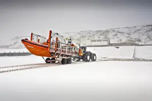 Sheringham Atlantic 85 inshore lifeboat The Oddfellows B-818 on a launching trailer on the beach, snow covering everything and station in the background