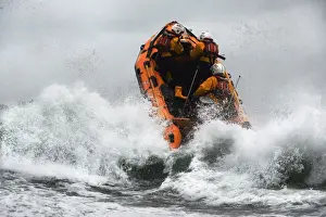 St Agnes D-class inshore lifeboat Blue Peter IV D-641 heading through a breaing wave. Crew members Gavin Purcell, Gavin forehead and Richard Llewellyn on board