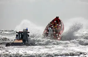 St Bees Atlantic 85 class inshore lifeboat Joy Morris MBE B-831 being launched from a trailer in rough seas. Four crew on board, bow high out of the water