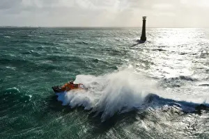 St Marys Severn class lifeboat 17-11 in rough seas off the lighthouse at Bishops Rock, the westnermost point of the Isles of Scilly