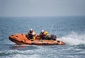 Swanage D-class inshore lifeboat Jack Cleare D-613 heading from right to left three crew on board Swanage D-class inshore lifeboat Jack Cleare D-613 heading from right to left three crew on board